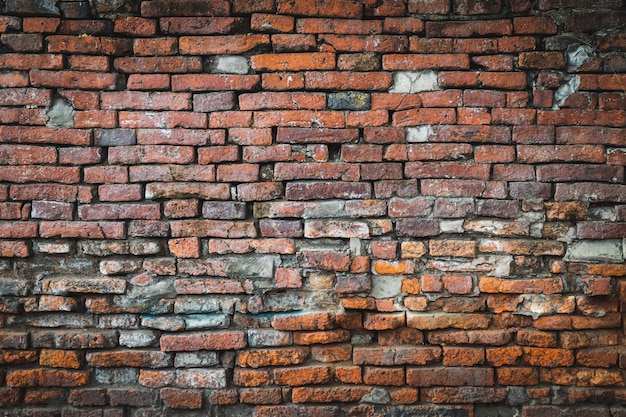 Vecchia priorità bassa arancione del muro di mattoni e la riparazione