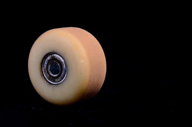 Vecchia ruota da skate consumata vintage su sfondo nero