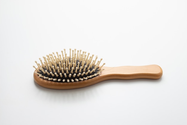 Vecchia spazzola per capelli di legno su fondo bianco