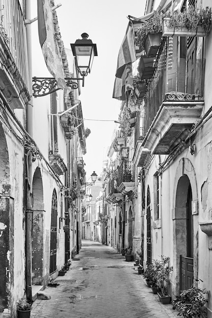 Vecchia strada nella città vecchia di Siracusa, Sicilia, Italia. Bianco e nero