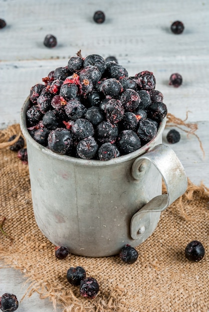 Vecchia tazza rustica con mirtilli e ribes congelati