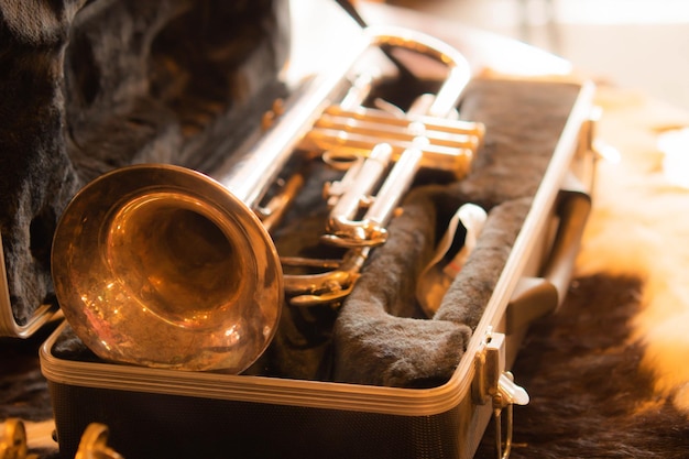 Vecchia tromba d'oro in una custodia di pelliccia nera Primo piano bellissimo strumento sassofono vintage in scatola