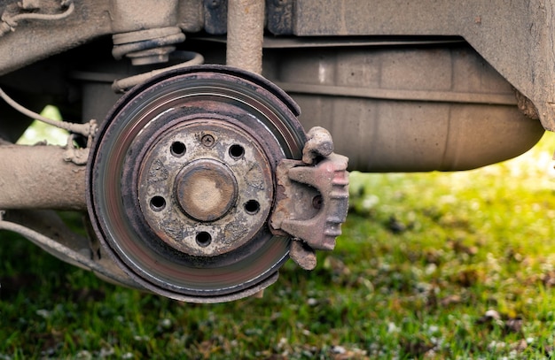 Vecchie auto sporche e arrugginite parti frenanti Freno a disco arrugginito e pinza sull'auto da vicino