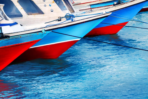 Vecchie barche da pesca rosse e blu nel porto di mare Riflessi colorati nell'acqua Sfondo del mare