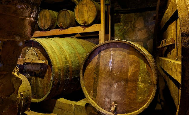 Vecchie botti di vino in primo piano scuro della cantina