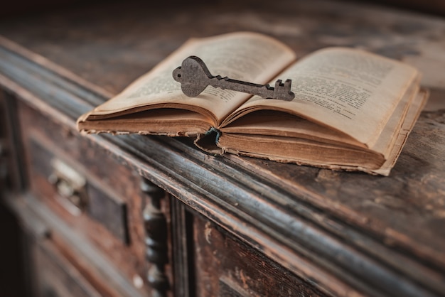 Vecchie chiavi d'annata su un vecchio libro avariato, di legno.