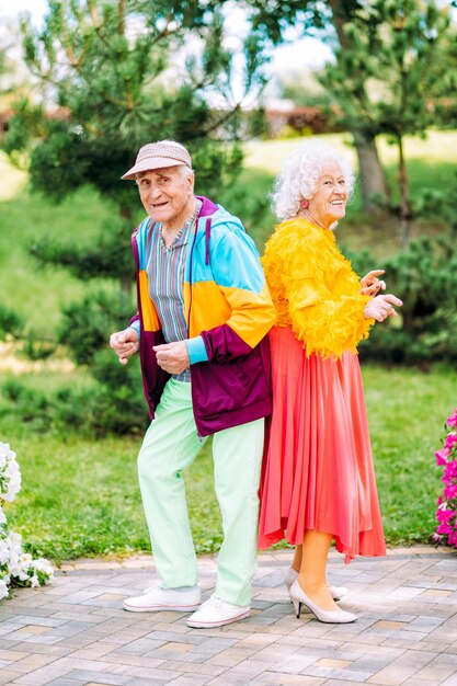 Vecchie coppie moderne che vestono vestiti colorati alla moda