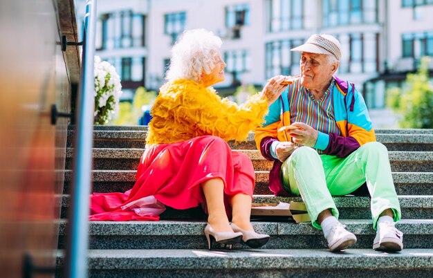 Vecchie coppie moderne che vestono vestiti colorati alla moda