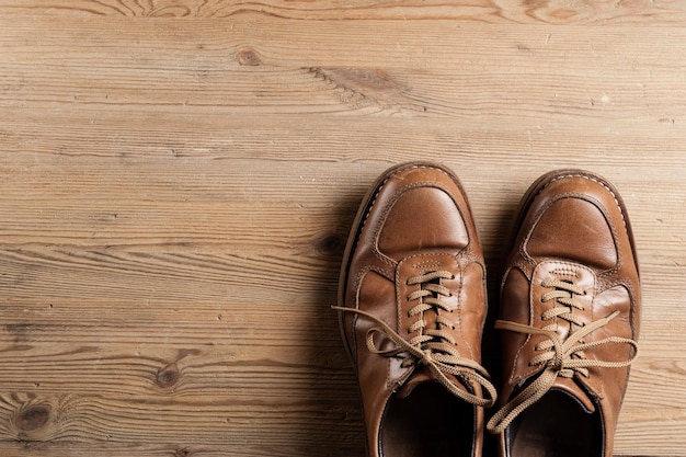 Vecchie scarpe in pelle marrone per uomo su fondo di legno