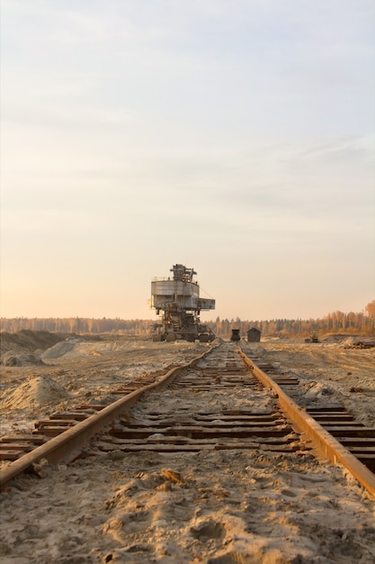 Vecchio abbandonato binario ferroviario gigante impilatore benna escavatore a catena in una cava di sabbia