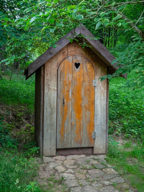 Vecchio bagno in legno in una foresta estiva