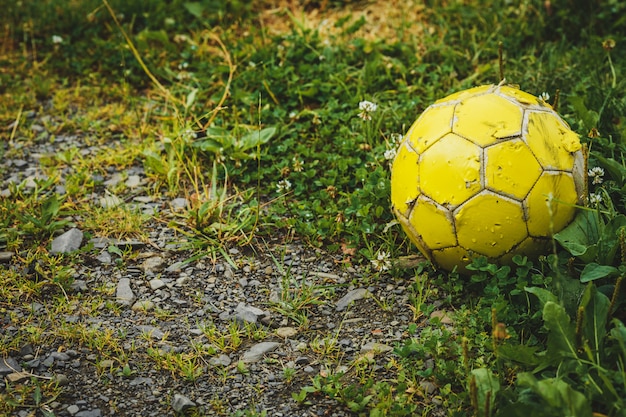 Vecchio calcio o pallone da calcio sull'iarda di ghiaia schiacciata