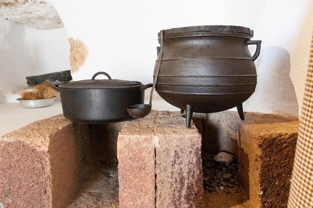 Vecchio calderone e padelle su un tavolo di legno in cucina.