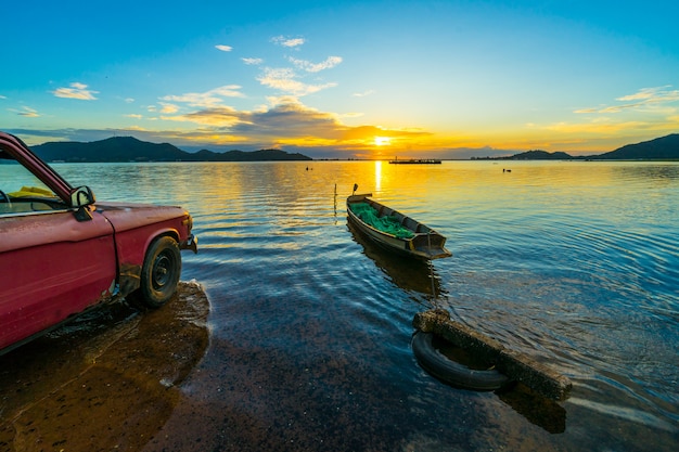 Vecchio camioncino parcheggiato sul lungomare con il tramonto al serbatoio di Bang Phra, Sriracha Chon Buri, Tailandia