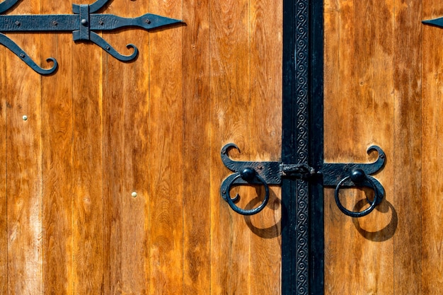 Vecchio cancello di legno con decorazione in metallo da vicino.