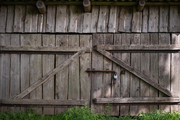 Vecchio cancello fatto di tavole stagionate in un fienile rustico Sfondo retrò in stile ecologico