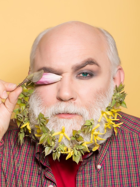 Vecchio con fiori e foglie in barba