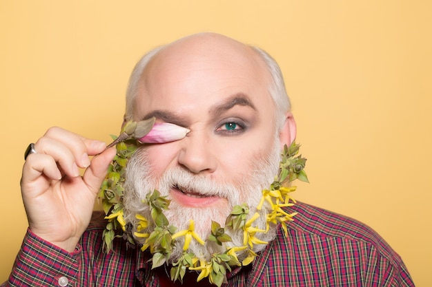 Vecchio con fiori e foglie in barba