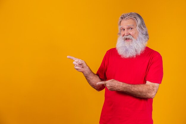 Vecchio con una lunga barba che punta di lato su uno sfondo giallo. Anziano con barba bianca.