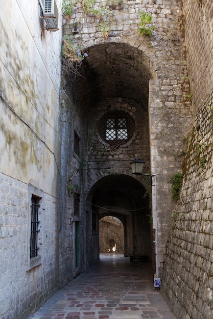 Vecchio corridoio di pietra con finestra rotonda nella città vecchia di Kotor