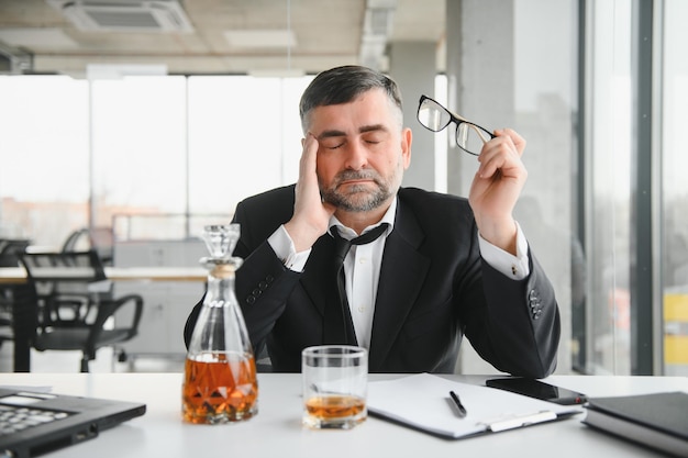 Vecchio dipendente maschio che beve alcol sul posto di lavoro