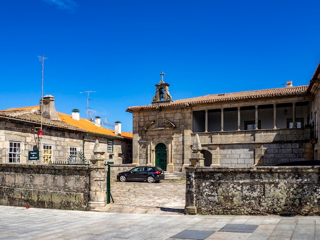 Vecchio edificio in pietra con recinzione murata e vicolo di ciottoli a Guarda Portogallo