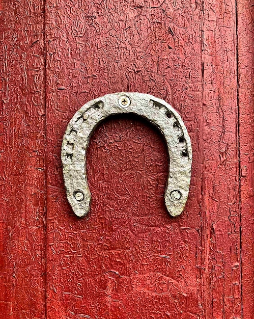 Vecchio ferro di cavallo su fondo di legno dipinto di rosso