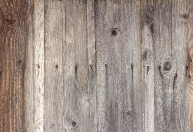Vecchio fondo di legno con crepe e chiodi, tavole oscurate e stagionate.
