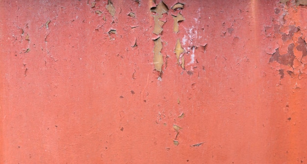 Vecchio fondo di metallo verniciato arrugginito. Trama di vernice peeling rosso.