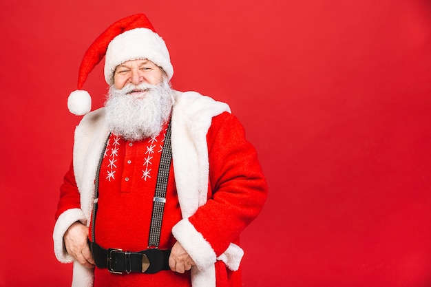 vecchio in costume di Babbo Natale isolato su sfondo rosso