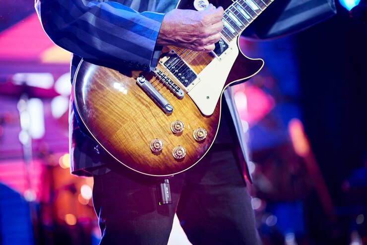 Vecchio irriconoscibile che suona la chitarra elettrica dal vivo in un concerto rock show