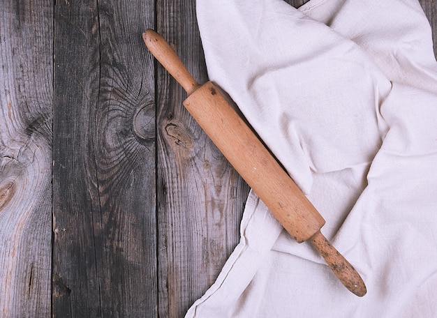 Vecchio mattarello di legno marrone sul tovagliolo di tela grigio