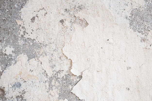 Vecchio muro danneggiato con intasamento di intonaco e vernice soffiato, danni alla vernice scrostata, danni causati dall'acqua sulla parete dell'edificio. Fondo astratto di lerciume