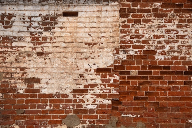 vecchio muro di mattoni con strati di vecchio intonaco e sfondo di vernice