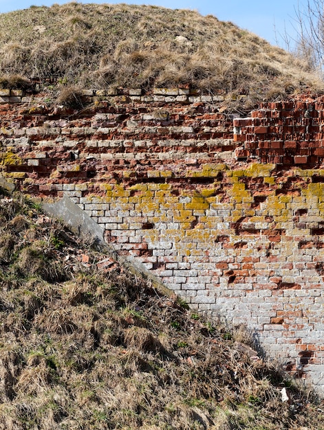 Vecchio muro di mattoni della fortezza, distrutto o danneggiato durante i combattimenti della guerra