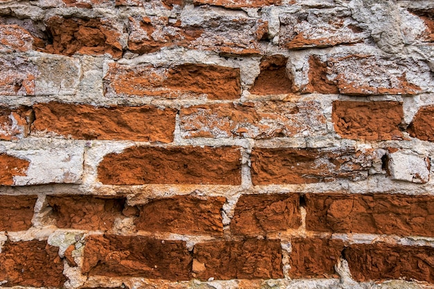 Vecchio muro di mattoni, vecchia struttura di blocchi di pietra rossa da vicino