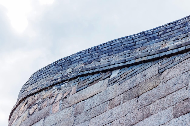 Vecchio muro di pietra sullo sfondo del cielo nuvoloso. Girare un muro