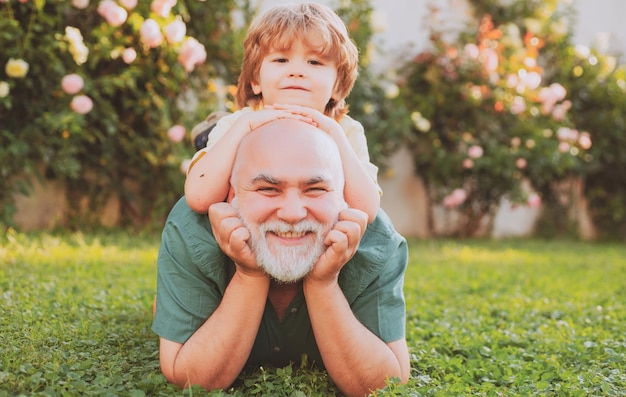 Vecchio padre gioca con il figlio felice festa del papà bambino felice con il padre che gioca all'aperto padre che dà così