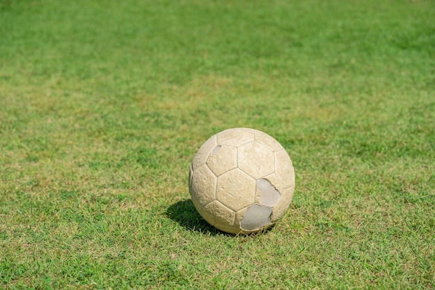 Vecchio pallone da calcio sull'erba verde del campo di calcio. Calcio d'epoca.