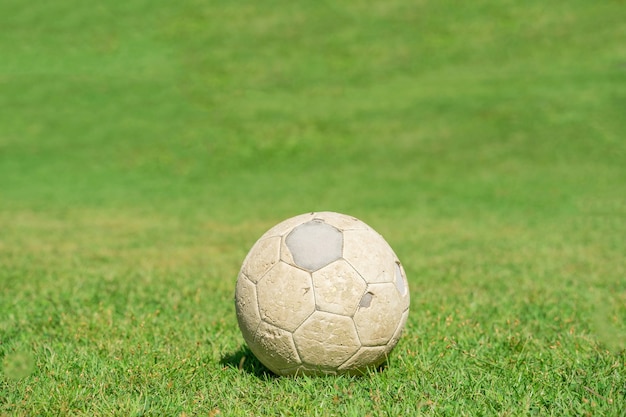 Vecchio pallone da calcio sull'erba verde del campo di calcio. Calcio d'epoca.