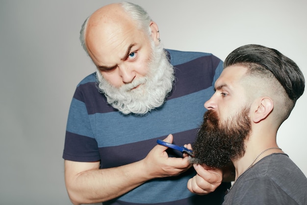 Vecchio parrucchiere e giovane uomo barbuto