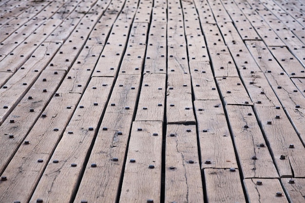 Vecchio pavimento in legno fatto di assi e rivetti arrugginiti