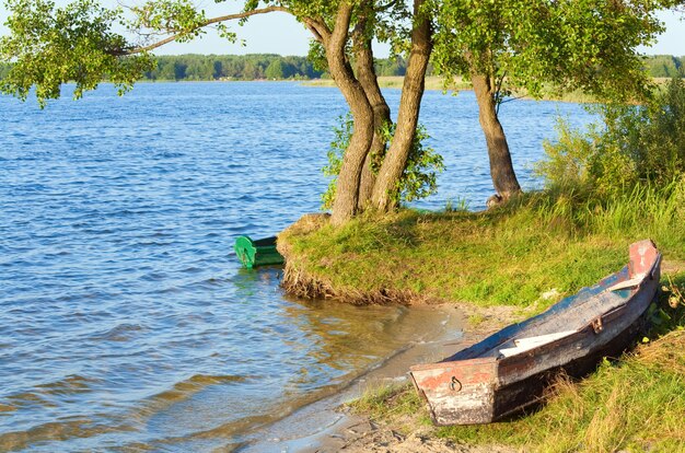 Vecchio peschereccio di legno vicino alla riva del lago di estate (Svityaz, Ucraina)