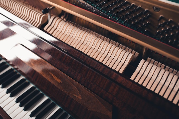 Vecchio pianoforte acustico vintage all'interno con martelli e archi da vicino Messa a fuoco selettiva dello strumento musicale