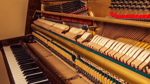 Vecchio pianoforte rotto in piedi al muro