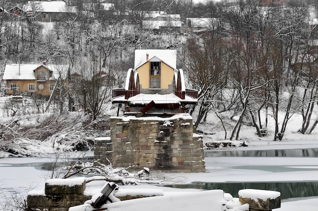 Vecchio ponte stradale in acciaio rovinato sul fiume dopo la nevicata