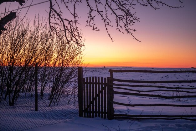 Vecchio recinto di legno e magica foto di sfondo della natura del tramonto invernale