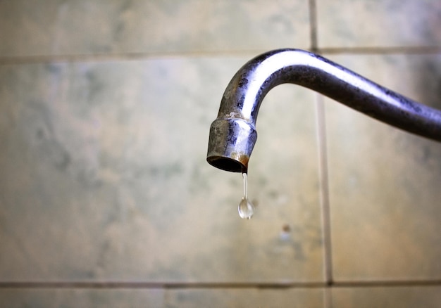 Vecchio rubinetto sporco nel bagno Rubinetto dell'acqua vecchio Gocciola da un vecchio rubinetto arrugginito