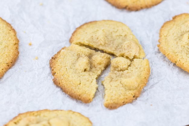 Vecchio tavolo di legno con fuoco selettivo del primo piano del colpo del primo piano dei biscotti di macadamia freschi