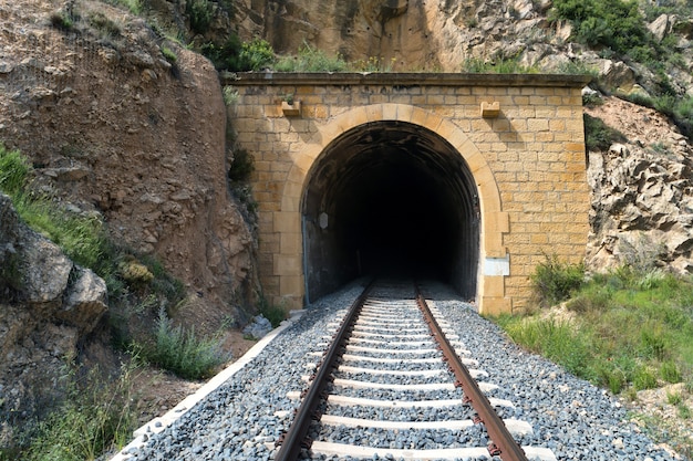 Vecchio tunnel del treno con ferrovia in montagna